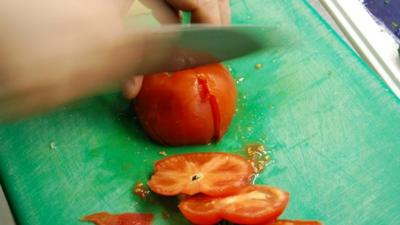 Chef slicing tomatoes