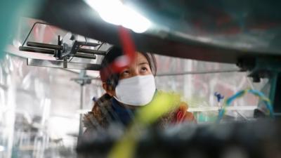 A woman working in a Chinese textile factory that exports clothing to the US and Europe