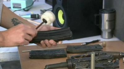 Man beating an empty machine gun magazine