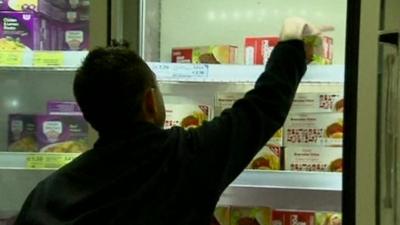 Man removing burgers from freezer cabinet