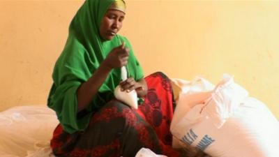 A woman ties an aid bag