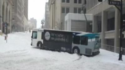 A bus skids off an icy road in Kansas City Missouri and crashes into a street lamp