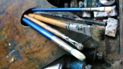 Paintbrushes, a palette and oil paints