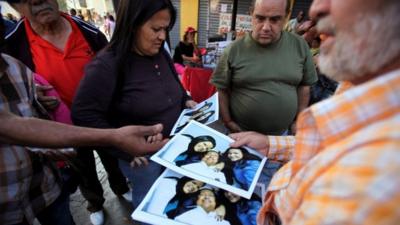 A man sells Chavez prints at 20 bolivars each