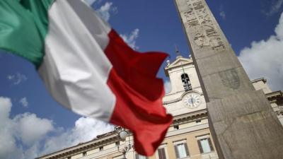 An Italian flag in front of the Montecitorio palace