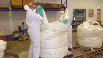 Bags of drugs being taken out of larger sacks