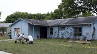 Engineers work in front of a home where sinkhole opened up underneath a bedroom and swallowed a man in Seffner, Florida