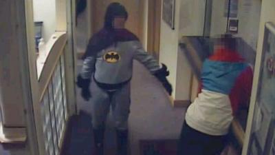 Man in Batman outfit in police station