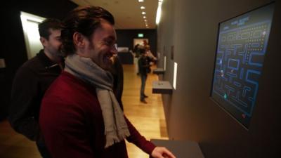 Man watches PacMan at the MoMA