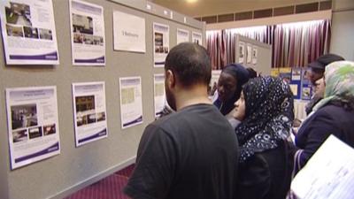 Residents looking at housing adverts