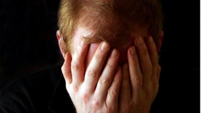 A man holding his head in his hands