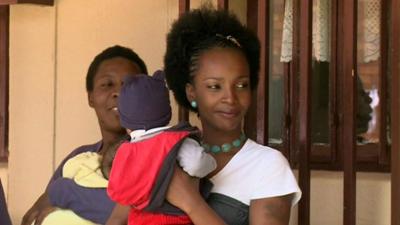 A mother with her baby outside a prison cell