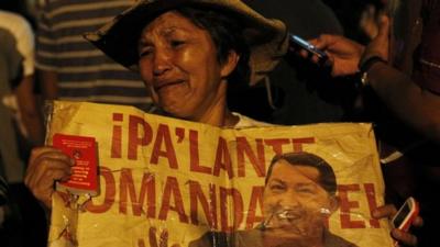 Woman cries holding poster of Hugo Chavez