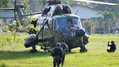 Malaysia Army commandos prepare to board a helicopter