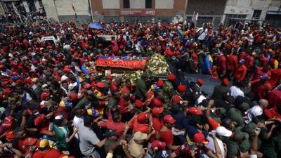 The hearse carrying President Chavez's coffin passes through packed streets