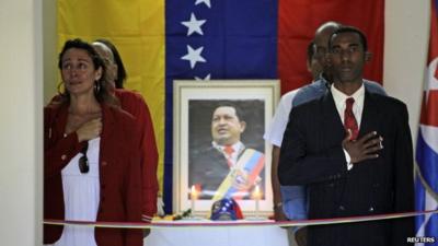 People mourn beside a portrait of the late President Hugo Chavez during a vigil in Venezuela's embassy in Havana