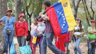 Man carrying Venezuelan flags