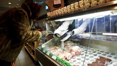 Woman at a butcher shop