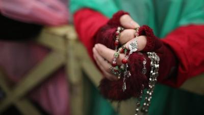 A woman holds rosary beads