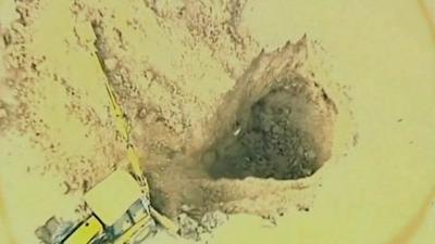 Digger filling in golf course sinkhole