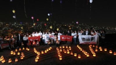 Syrian and local children form the word "Syria" with candles during a moment of silence the night before the second anniversary of the start of the Syrian Revolution at the Citadel