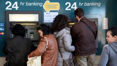 People withdraw money from ATMs in Nicosia, Cyprus. Photo: 17 March 2013