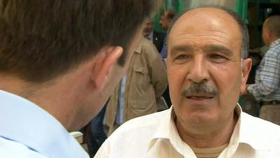 Ben Brown speaks to an man in Baghdad market