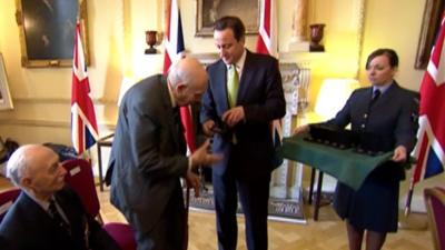 Prime Minister David Cameron presenting a veteran with an honour