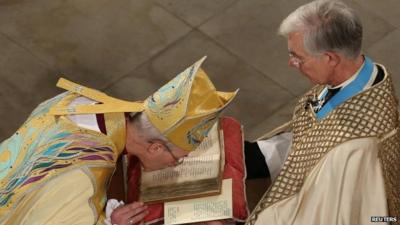 Archbishop kisses bible