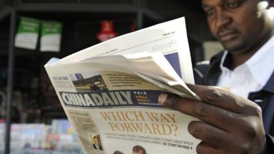 A man in Kenya reading a newspaper