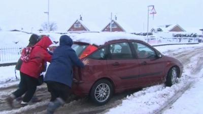 People push a car