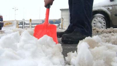 Man clearing snow with shovel