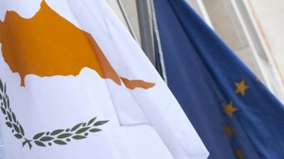 The Cypriot, left, and EU flag