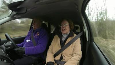Elderly woman being driven in a car