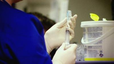 A nurse preparing an injection