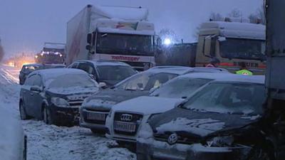 Lorries and cars on snowy road