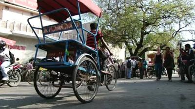 A tricycle taxi looks for tourist passengers