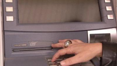 Woman's hand typing in numbers at cash machine