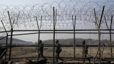 South Korean army soldiers patrol along a barbed-wire fence at the Imjingak Pavilion near the border village of Panmunjom on 15 March 2013