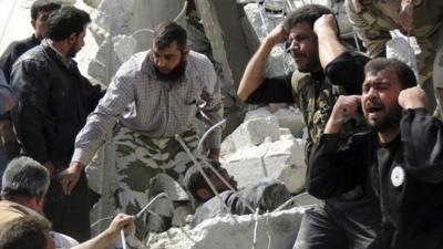 People search for casualties under the rubble at a site hit by what activists say was an air strike in Daiaat Al-Ansari neighborhood, Aleppo March 30, 2013.