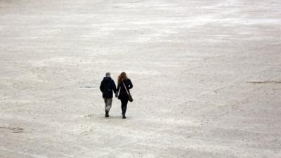 A couple walk on the beach