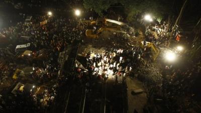 Rescue workers look for trapped people after building collapses in Thane, Mumbai, India. 4 April 2013