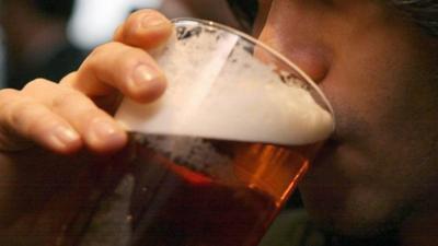 A man drinking a pint of beer