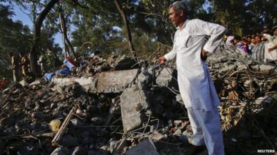 A man stands on the rubble of a collapsed building in the Thane district, near Mumbai