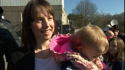 A mother in a queue for MMR jabs in Swansea