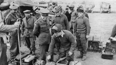 22nd December 1950: An American officer inspects a British cooking area near the front lines of battle