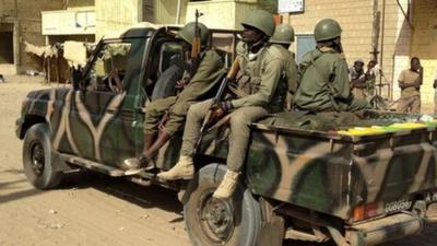 Malian soldiers patrol the streets