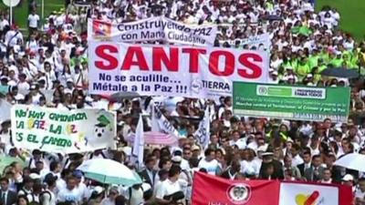 Crowds holding banners march in Colombia