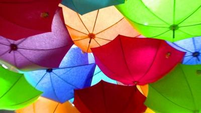 Some of Jacques Demy's colourful umbrellas hanging from a ceiling