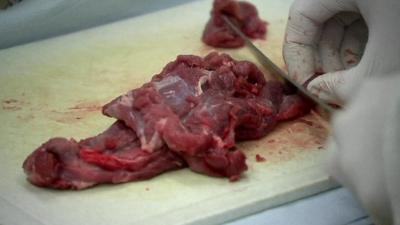 Some meat being cut on a chopping board